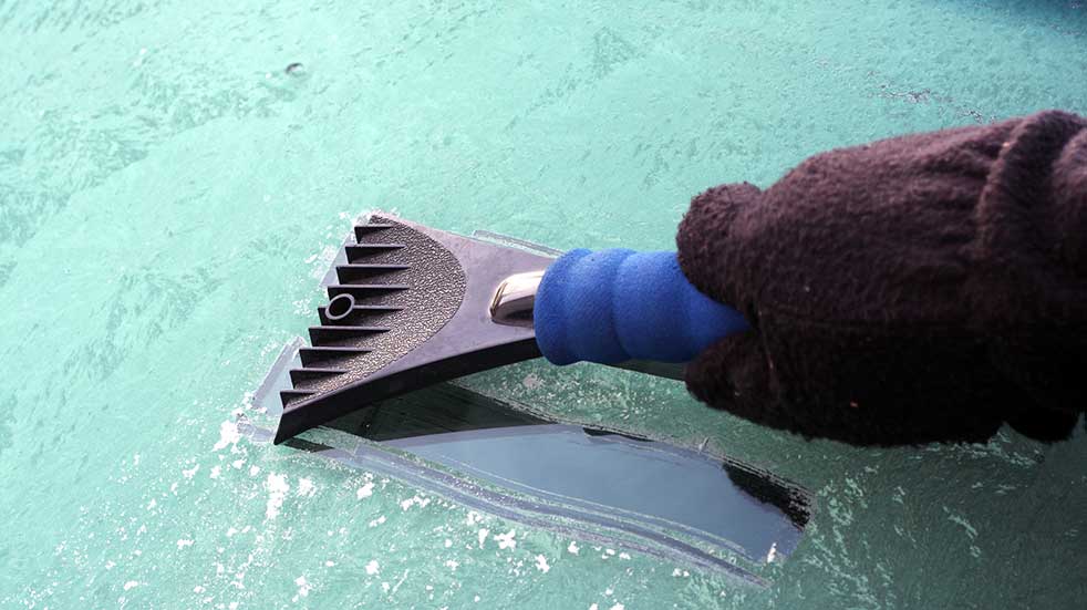 Winter driving scraping windscreen